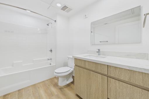 A white bathroom with a toilet, sink, and bathtub.