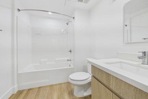 A white toilet sits next to a white sink in a bathroom.