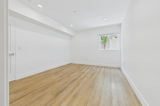 A room with wooden flooring and white walls.