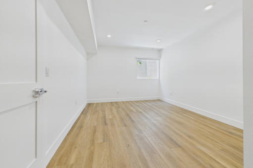 A room with wooden flooring and white walls.