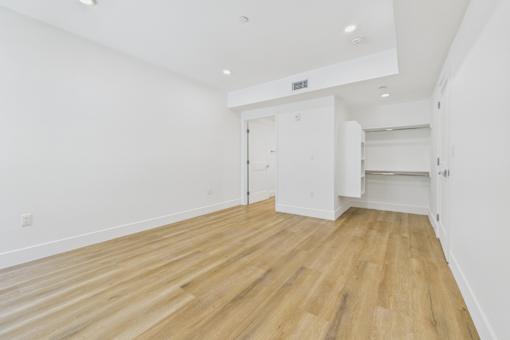 A room with wooden flooring and white walls.