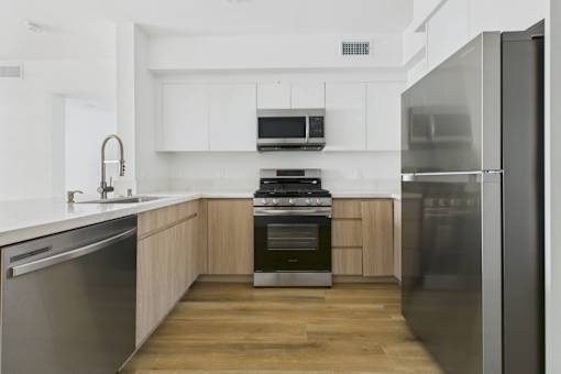 A modern kitchen with stainless steel appliances and wooden cabinets.