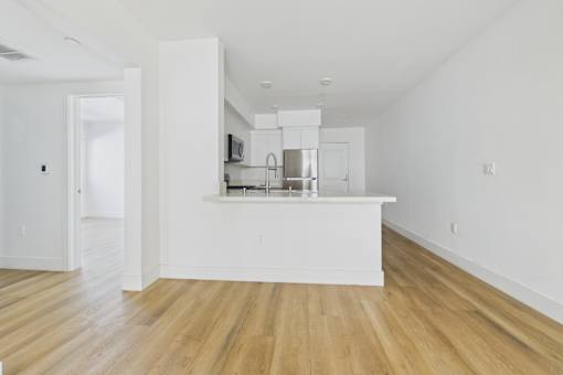 A kitchen with wooden floors and white walls.