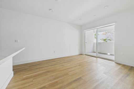 A room with wooden flooring and a sliding glass door.