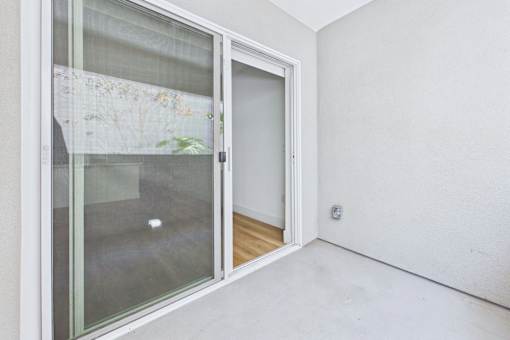 A room with a sliding glass door and a white wall.