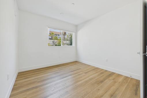 A room with wooden flooring and a picture on the wall.