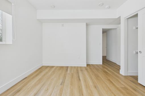 A room with wooden flooring and white walls.