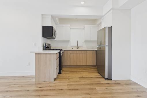 A kitchen with wooden floors and white walls.