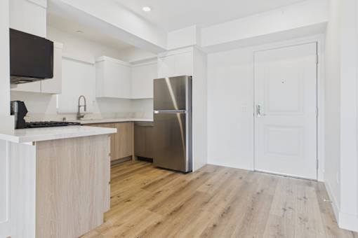 A kitchen with white cabinets and a wooden island.