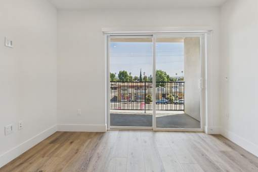 A room with a sliding glass door leading to a parking lot.