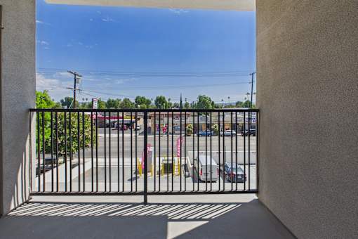 A view from a balcony looking out at a parking lot.
