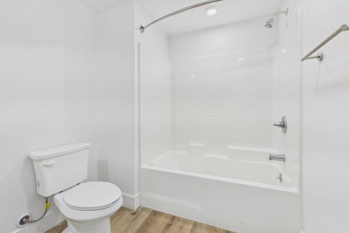 A white toilet is next to a white bathtub in a bathroom.