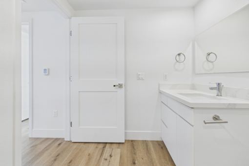 A white bathroom with a sink and a toilet.