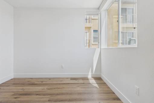 A room with a white wall and a wooden floor.
