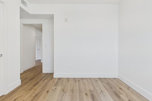 A room with wooden flooring and white walls.