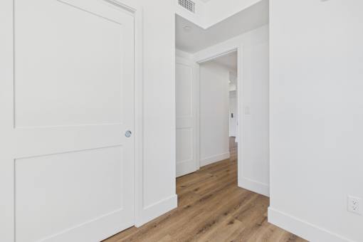A white door is on the left and an open doorway is on the right.