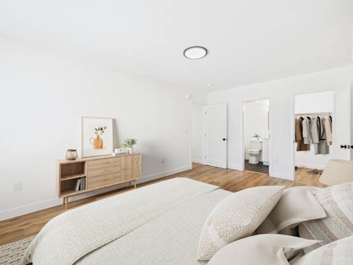 A bedroom with a bed, dresser, and mirror.