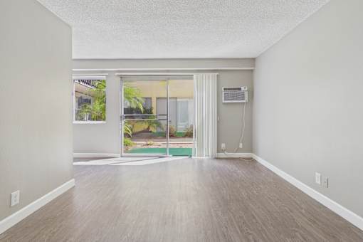 A room with a sliding glass door leading to a patio.