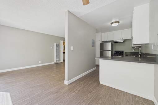 A kitchen with a refrigerator, stove, and cabinets.