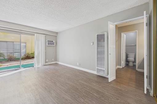 A room with a sliding glass door leading to a balcony.