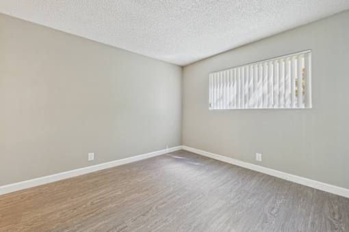 A room with a window and wooden flooring.