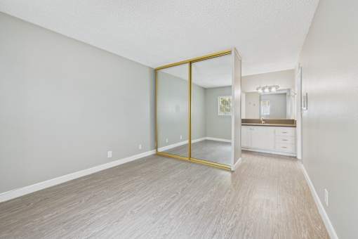 A room with a sliding glass door leading to a kitchen.