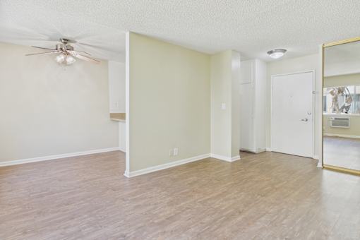 A room with a ceiling fan and a mirror on the wall.