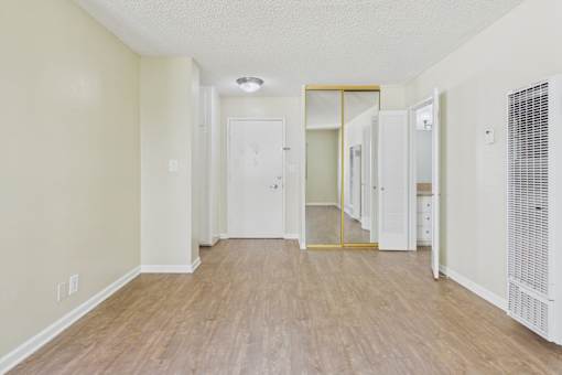 A hallway with a white door and a mirrored wall.