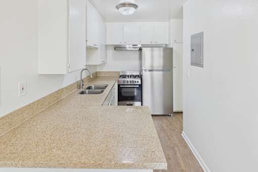 A kitchen with a granite counter top and stainless steel appliances.