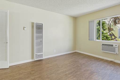 A room with a window and a wall-mounted air conditioner unit.