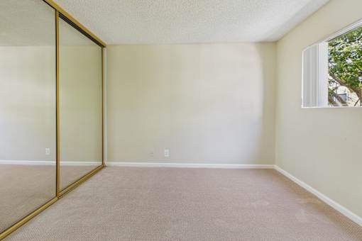 A room with a carpeted floor and a sliding glass door.