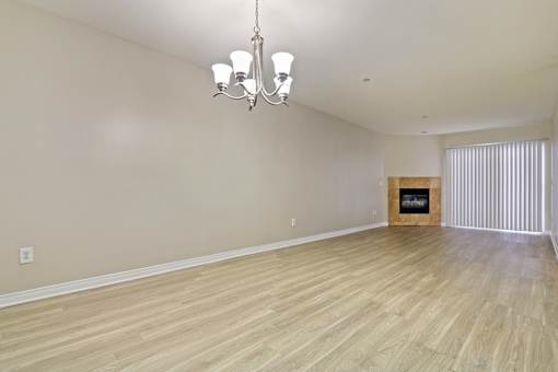A room with wooden flooring and a chandelier.