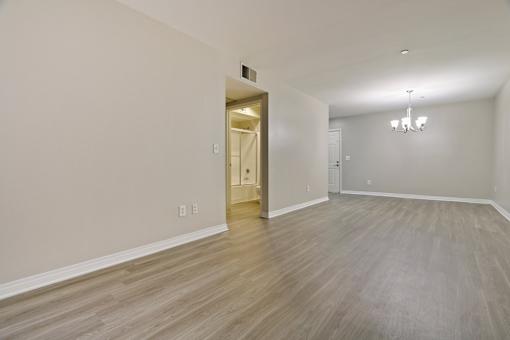 A room with a wooden floor and a chandelier.