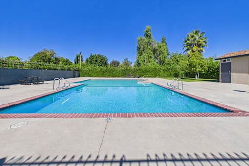A large outdoor swimming pool with a red and white border.