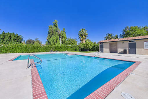A swimming pool with a red border and a clear blue sky in the background.