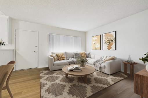 A living room with a couch, coffee table, and two framed pictures on the wall.