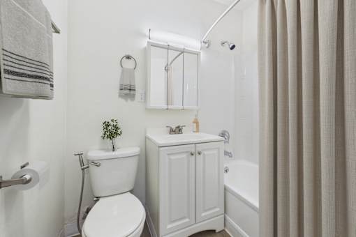 A white toilet sits next to a white sink in a bathroom.