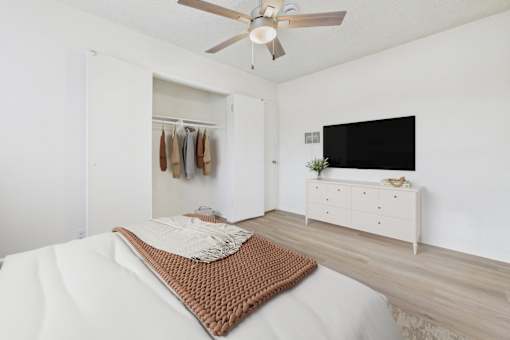A bedroom with a bed, a dresser, and a TV.