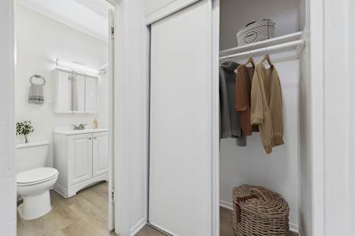 A white bathroom with a toilet, sink, and a wicker basket.