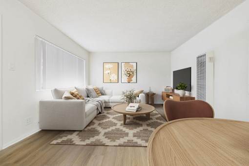 A living room with a grey couch, a brown chair, and a wooden table.