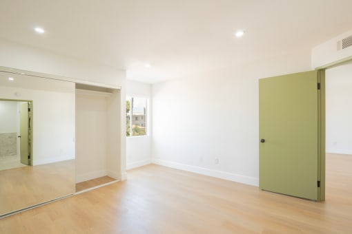 a living room with white walls and a green door