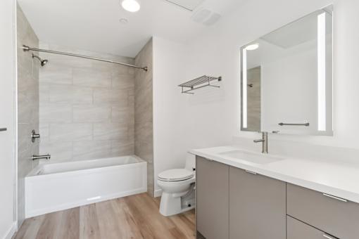 A white bathroom with a tub, toilet, and sink.
