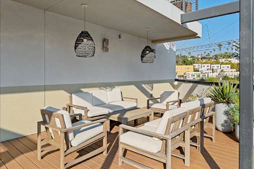 A patio with wooden furniture and hanging lamps.