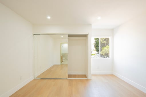a living room with white walls and a sliding glass door