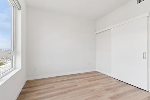 A room with a white wall and a white closet.