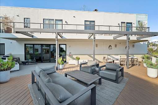 A modern house with a wooden deck and outdoor furniture.