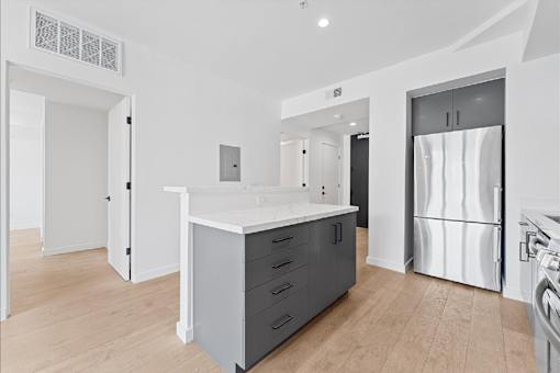 A modern kitchen with a white island and stainless steel appliances.