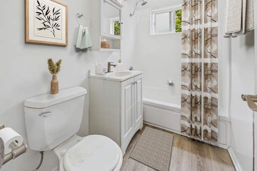 A white toilet sits next to a white sink in a small bathroom.