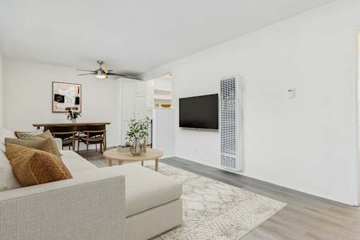 A living room with a white couch and a television.