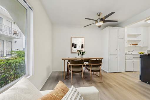 A dining room with a table and chairs and a ceiling fan.